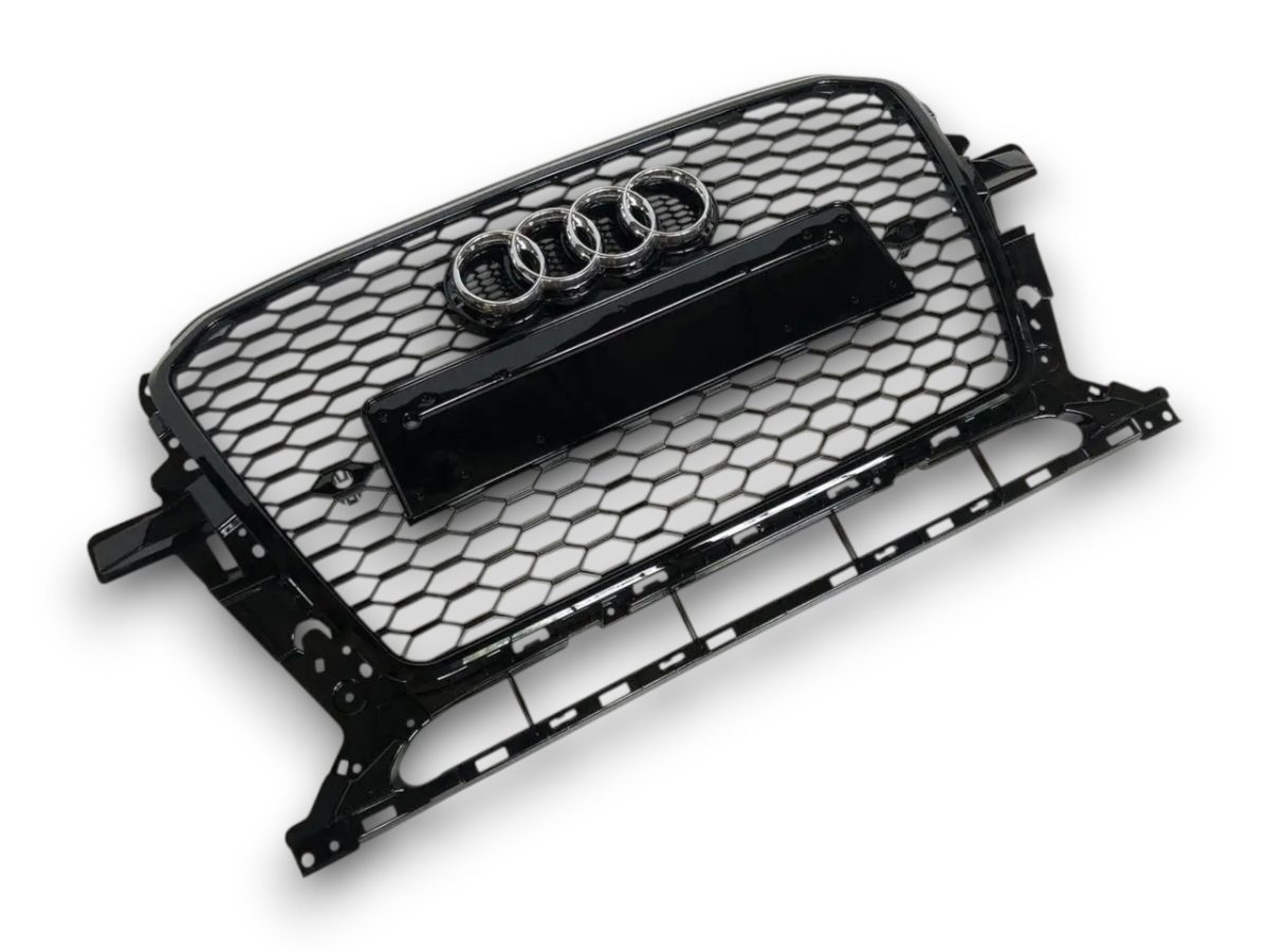 angled shot showing uninstalled RS style chrome frame radiator grille with emblem rings, license plate holder, and black honeycomb mesh