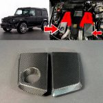 Mercedes-Benz G-Class W463 with Brabus engine bay highlighted. Close-up of red Brabus engine cover showing the location for carbon fiber trim pieces. Separate photo of two carbon fiber AMG-style engine trim covers displayed on a flat surface.