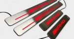 Close-up shot showing active red LED backlight illumination on brushed stainless steel door sill plate