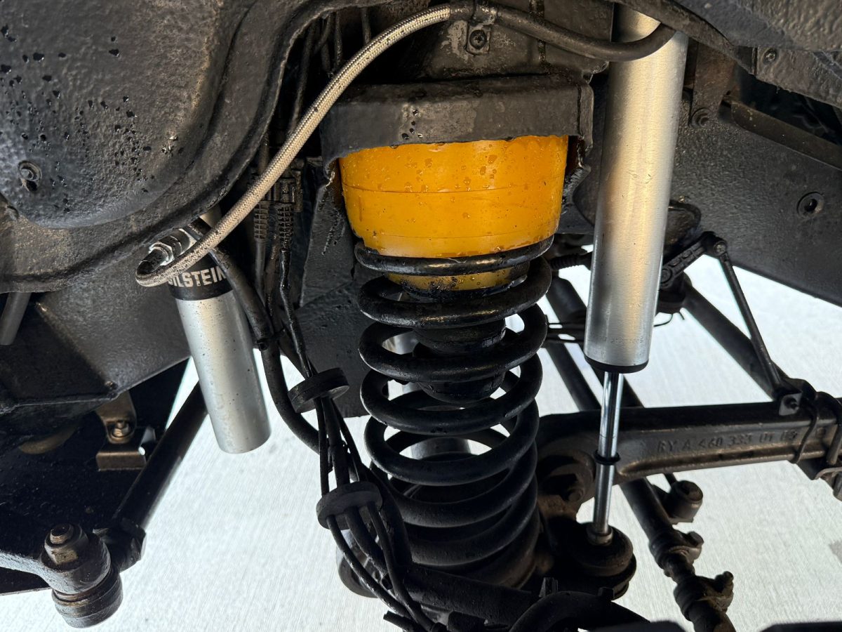 Dual Bilstein shock absorbers mounted next to heavy-duty coil spring on W463 6×6 suspension.