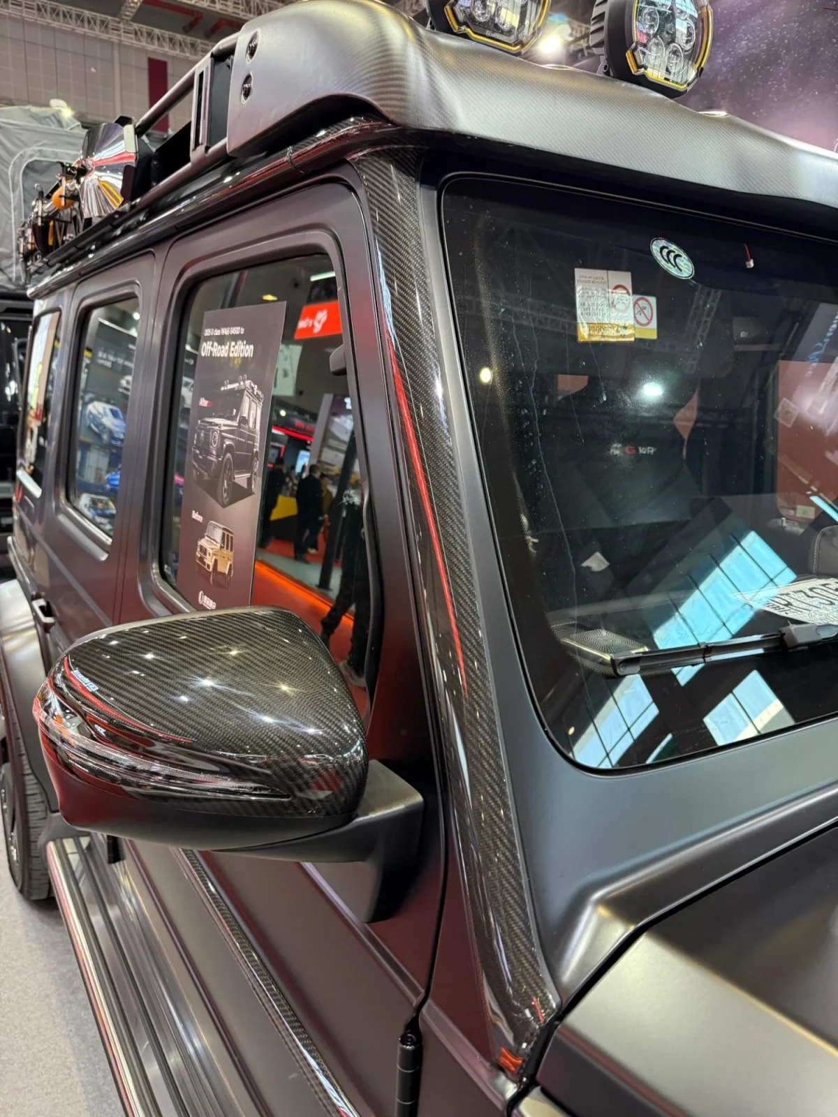 Close-up view of precision carbon fiber trim edge fitting against G-Wagon upper windshield frame