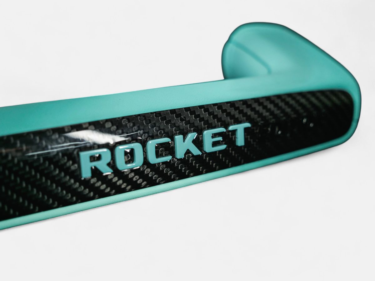 Detailed perspective showing right edge section of carbon fiber passenger grab bar cover with Tiffany text