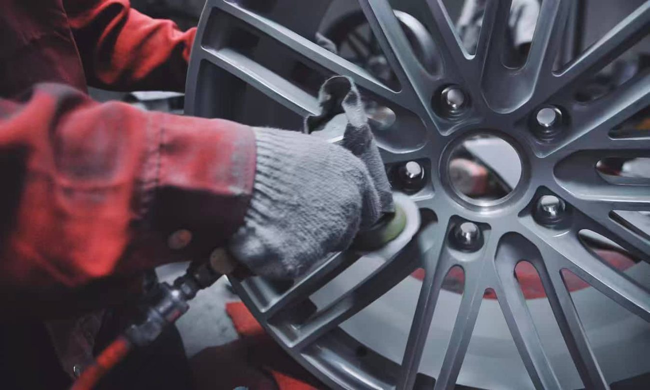 CNC lathe machining a raw aluminum billet into a forged wheel